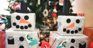 two snowman gift towers with gift cards in front of a Christmas tree