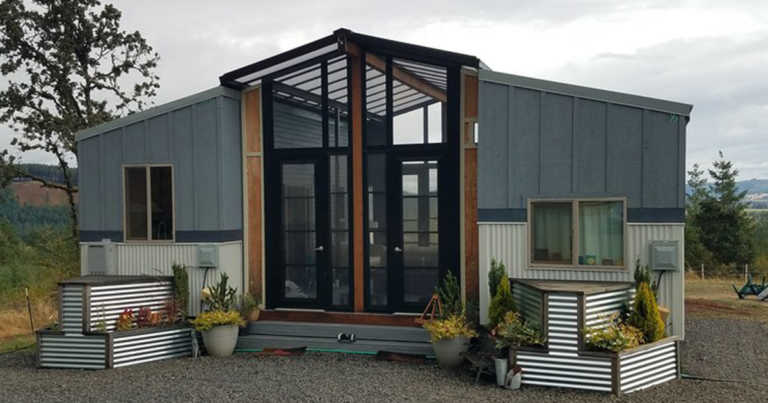Two Tiny Houses Are Connected With A Deck And Sunroom