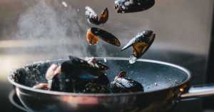 mussels being fried in a nonstick skillet