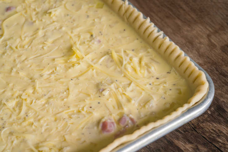 Unbaked quiche in a pan with fancy edges