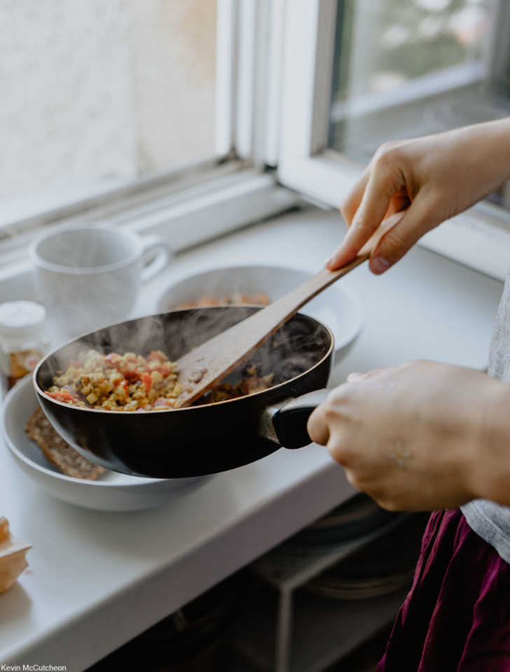 person making breakfast using a skillet