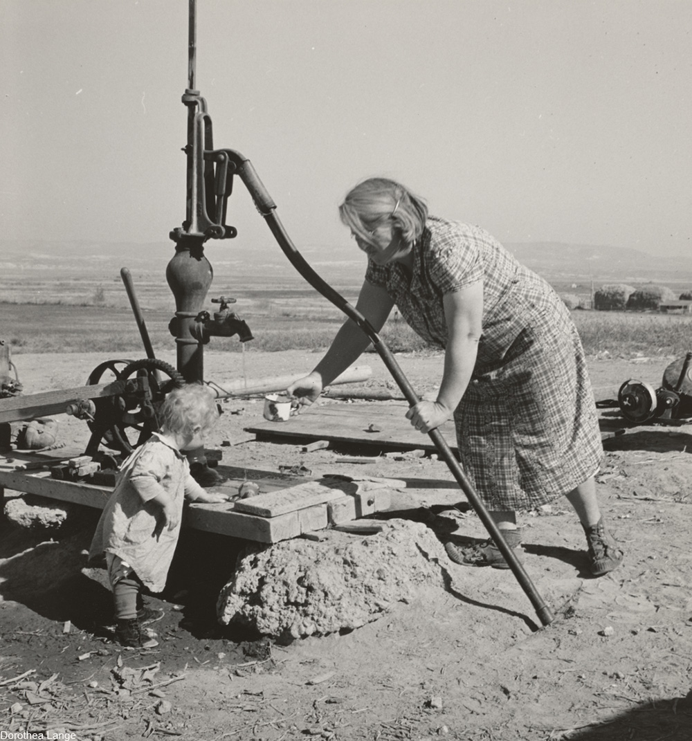 Mrs. Soper with youngest child at the well. Willow creek area, Malheur County, Oregon, 1939