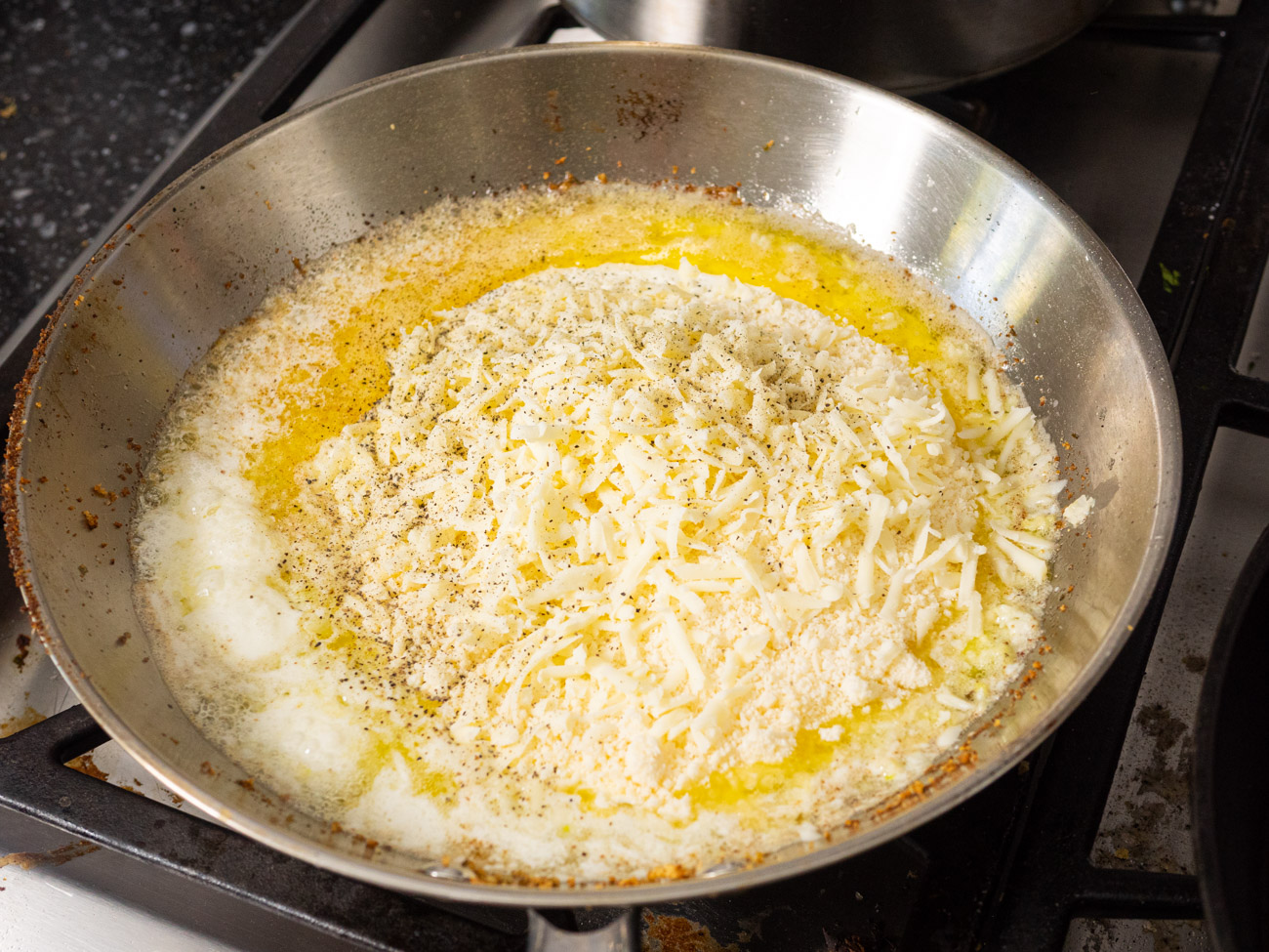 In the same skillet, melt the 6 tablespoons of butter. Add garlic and cook 1 minute. Stir in whipping cream, Parmesan, and mozzarella. Season to taste with salt and pepper and stir until sauce is smooth.