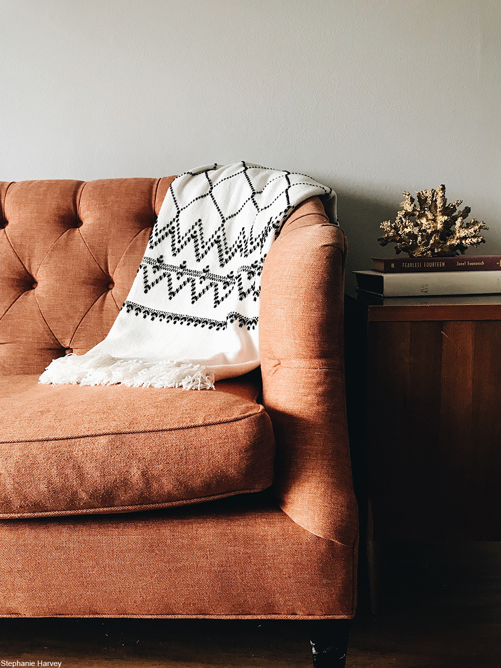 coral tufted sofa against a wall