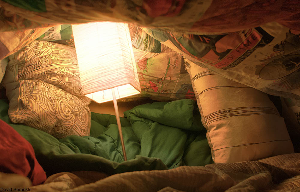 blanket fort with a lamp inside it