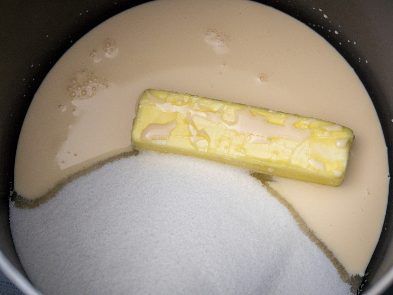 In a large saucepan combine butter, sugar, and evaporated milk. Boil for 5 minutes, stirring constantly.