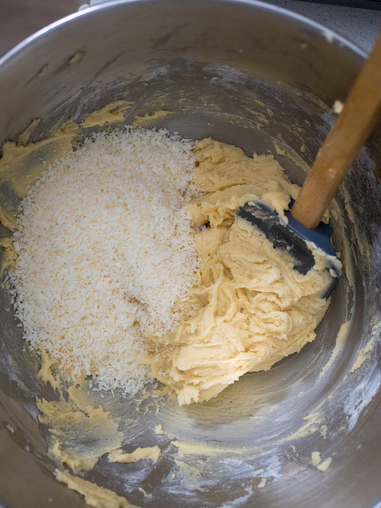 In a large mixing bowl cream together butter and sugar for cookies. Add in vanilla, egg, and milk and combine well. Slowly add flour to wet ingredients until just combined. Fold in un-toasted, shredded coconut.