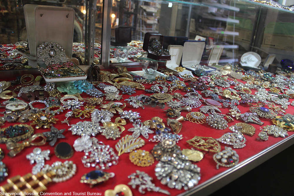 a selection of vintage brooches inside a glass case