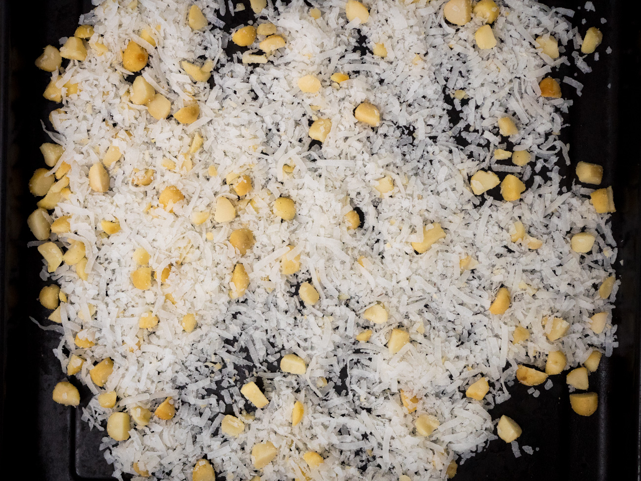 Prepare the garnish first by turning on the broiler and spreading 1/2 cup coconut flakes and 1/4 cup rough chopped macadamia nuts on a cookie sheet.