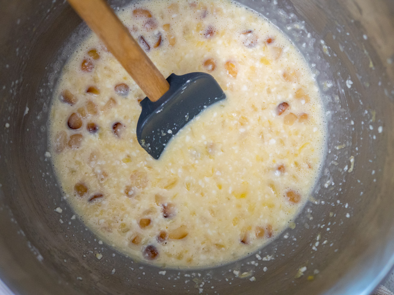 While the crust is baking, beat together eggs and powdered sugar in a large bowl. Add cream cheese, granulated sugar, crushed pineapple, and vanilla extract, and mix thoroughly. Fold in white chocolate chips and chopped macadamia nuts.