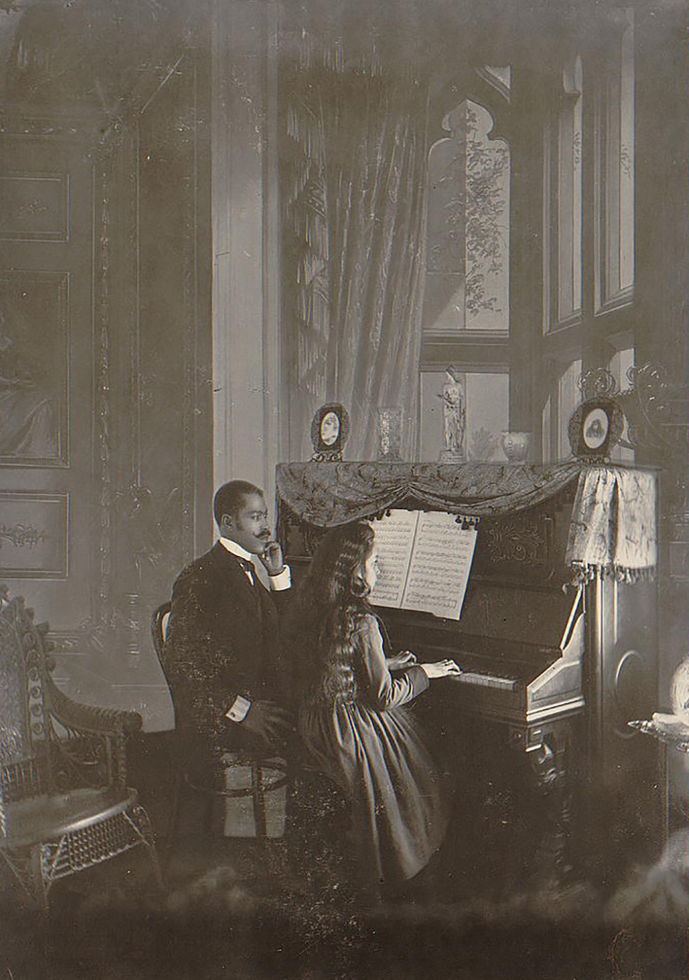 African American man giving piano lessons in the 1890s