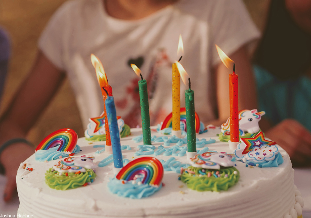 child's birthday cake with rainbows and candles