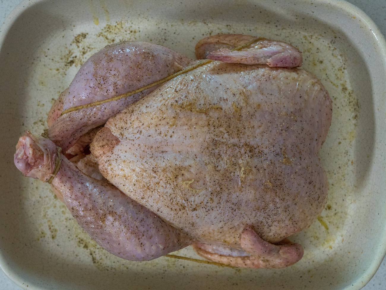 Brush chicken with 3 tablespoons of olive oil and rub in salt and pepper.