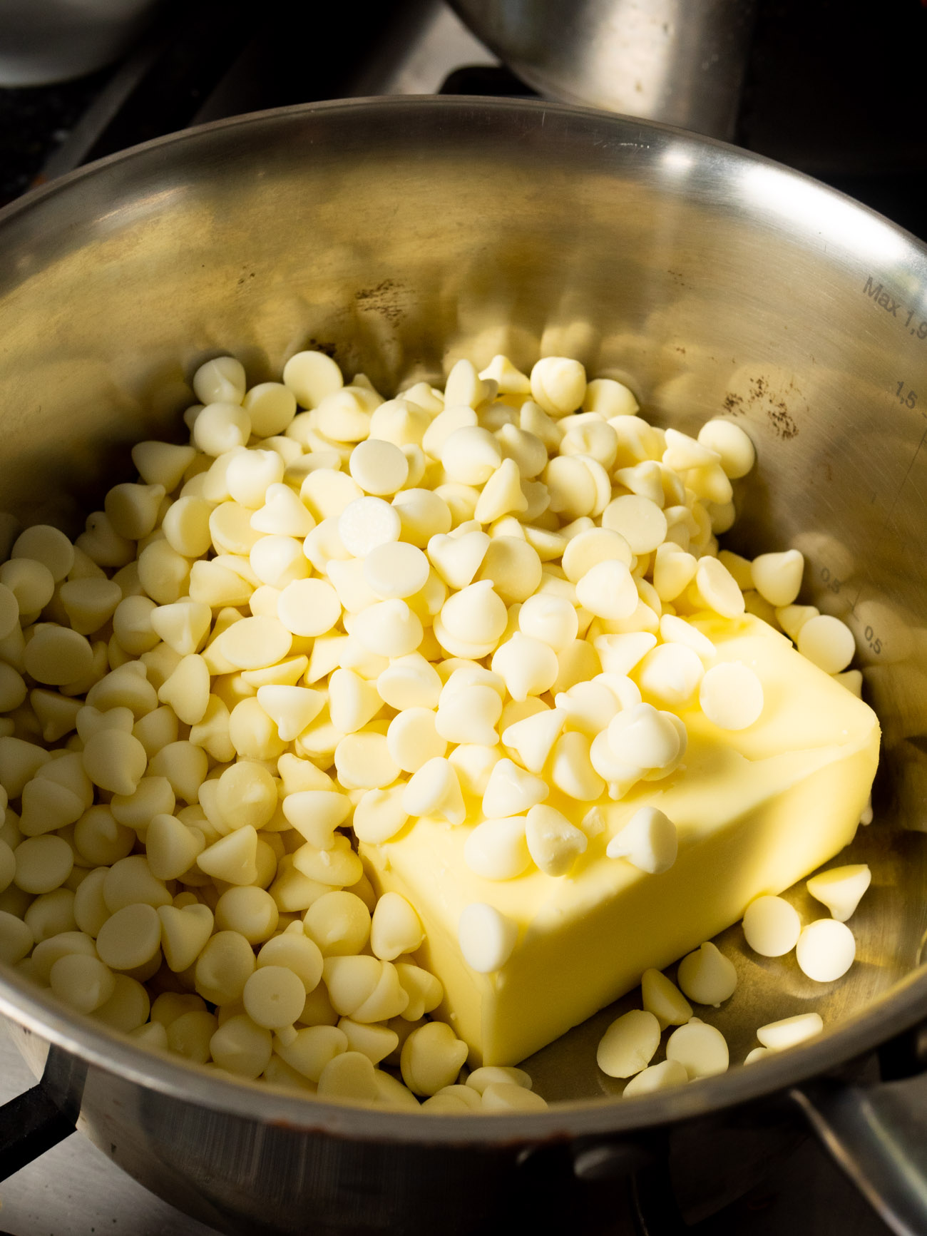 Melt the butter and white chocolate chips in a large pot over low heat, stirring frequently, until just melted. Remove from the heat and cool.