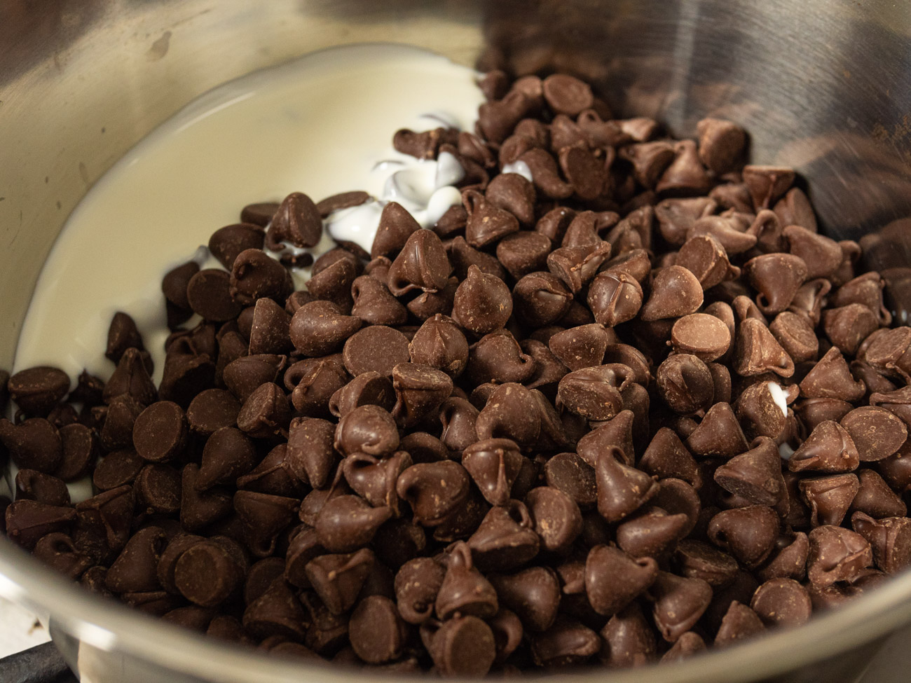 In a medium saucepan combine 1/4 cup of cream with 10 ounces (1 2/3 cups) chocolate chips. Whisk until smooth, but do not overheat. Add to this mixture vanilla, eggs, and salt and blend until smooth.