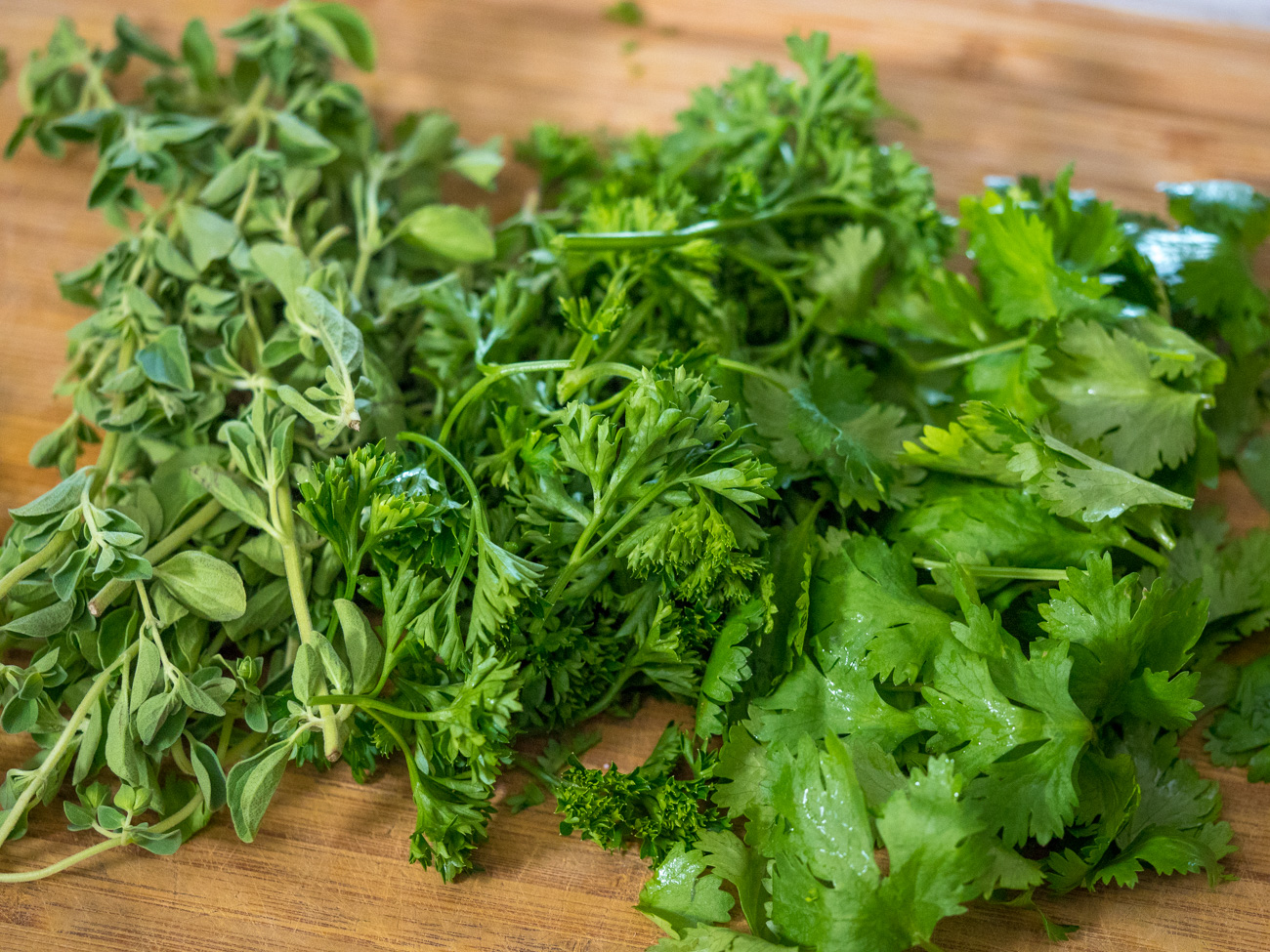 cilantro and parsley on a cutting board