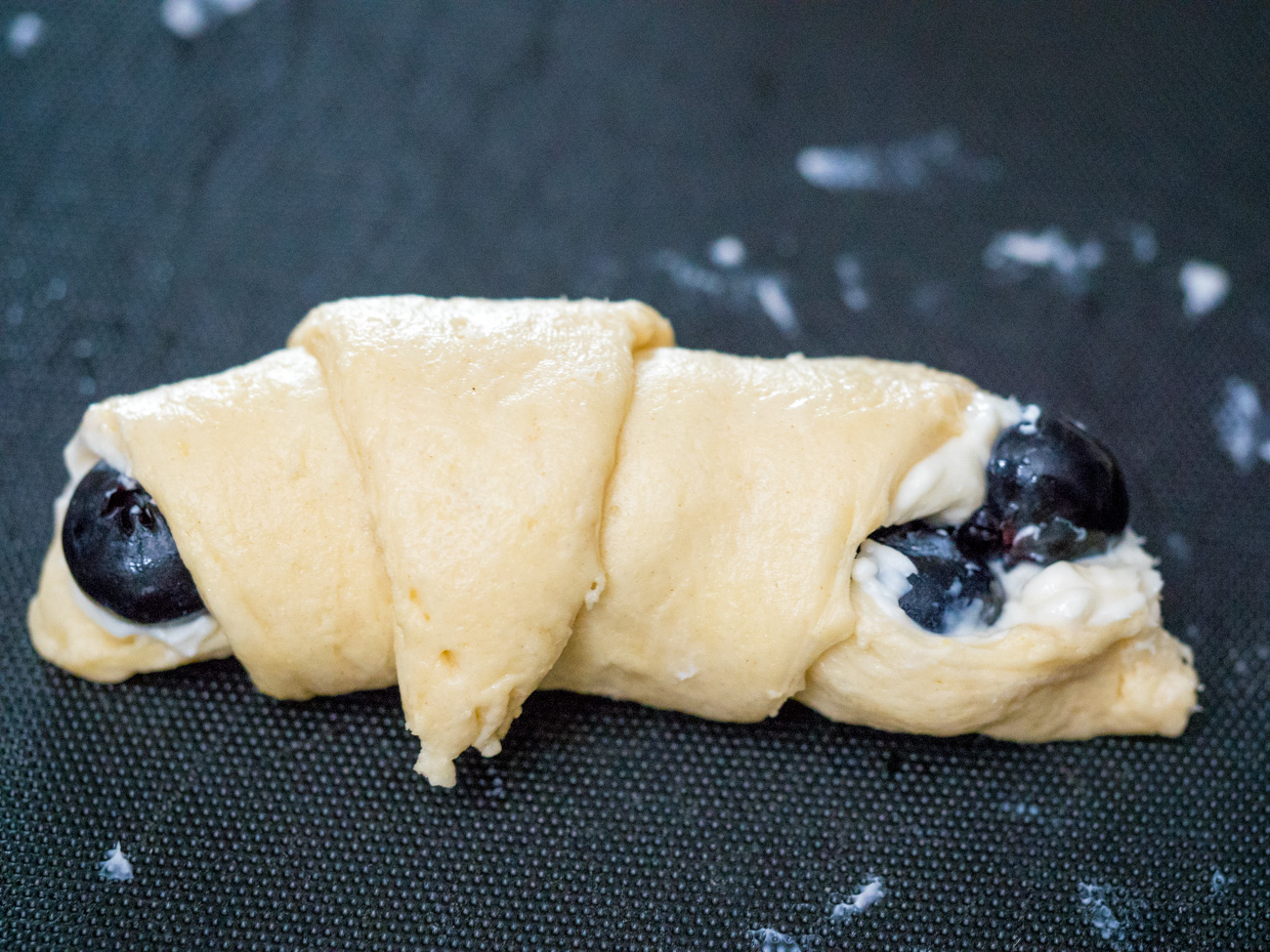 Roll the dough forward, starting with the end closest to you, all the way to the tip of the triangle.