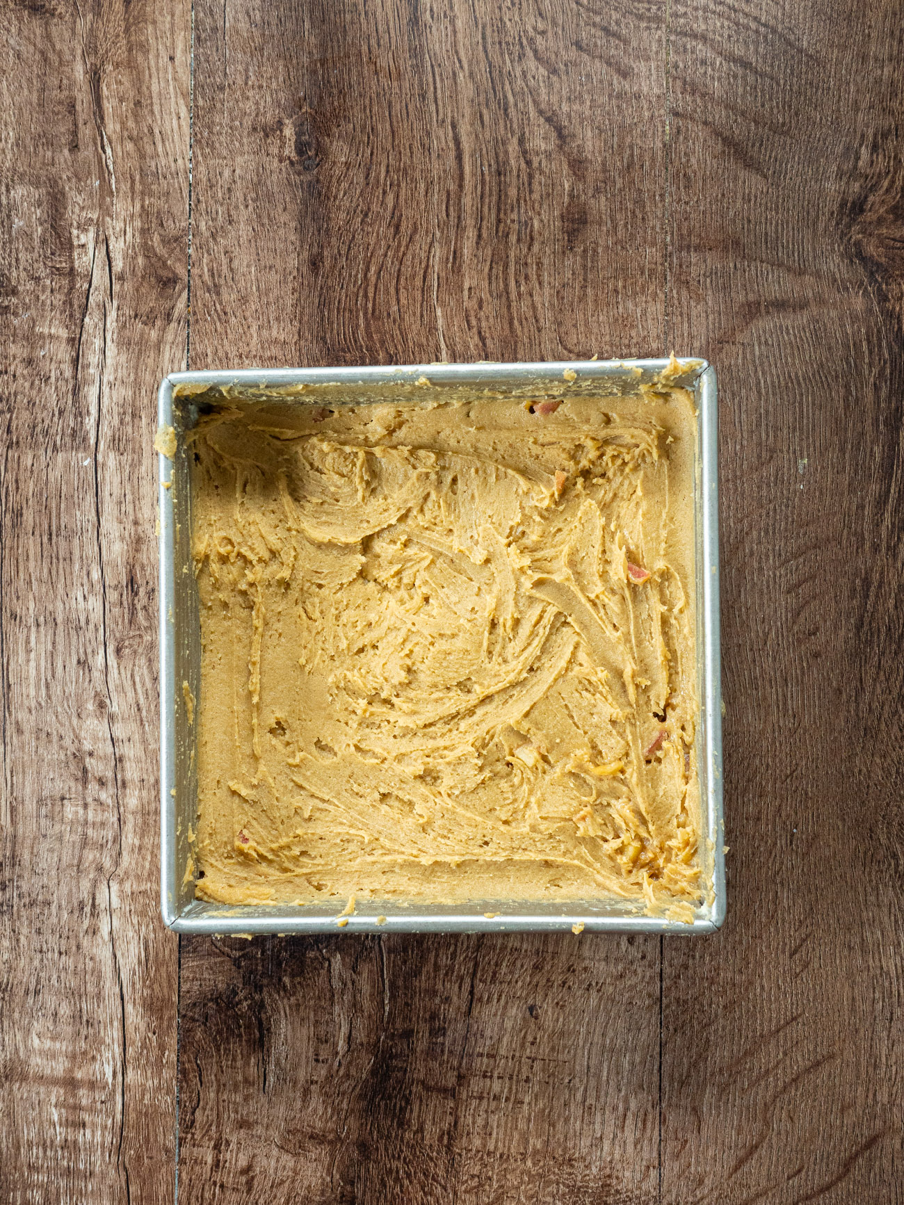 In the bottom of the prepared pan, spread half the blondie batter evenly, using a spatula (the mixture will be thick, you may find it easier to use your hands).