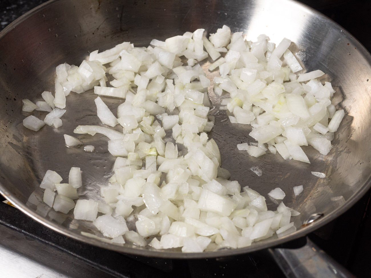 While the rice is cooking, add oil to a large skillet and sauté onion over medium heat until translucent (usually 2-4 minutes).