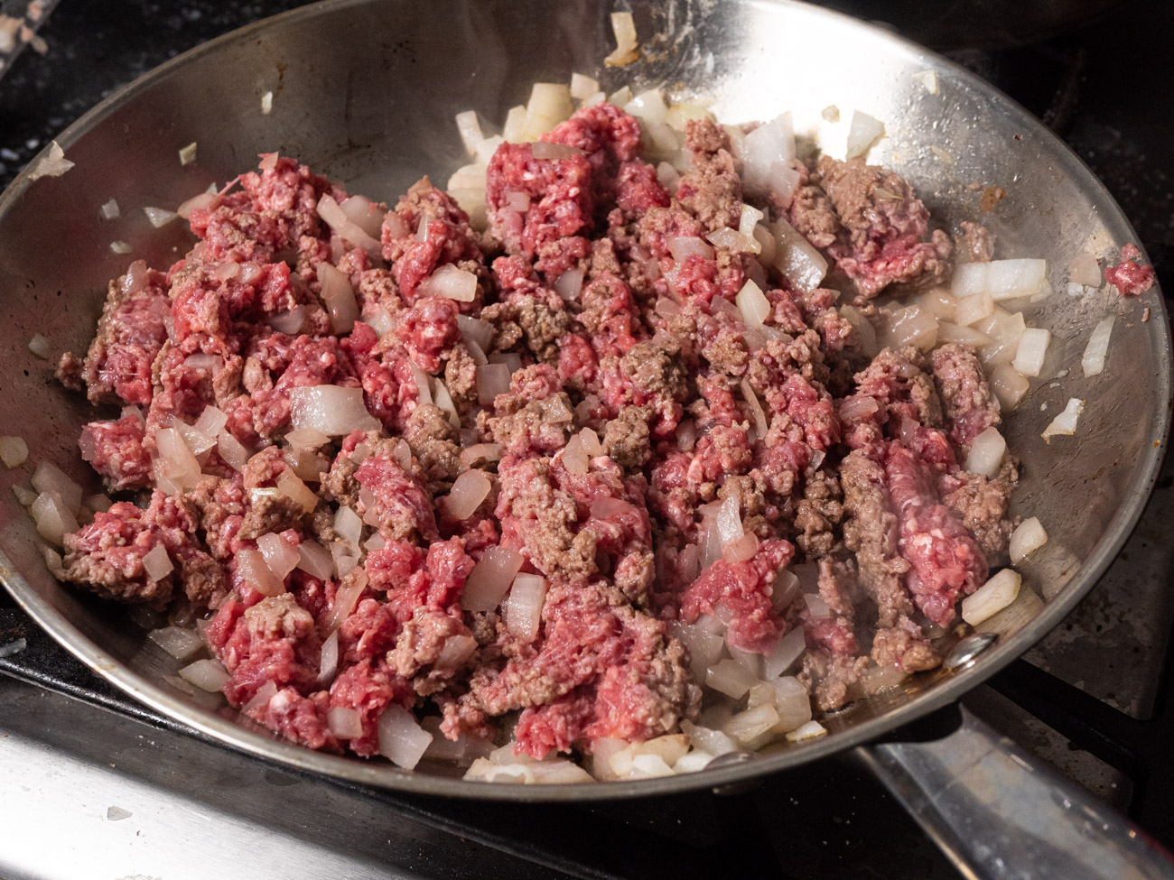 Add ground beef to skillet, cooking until no red remains in the beef.