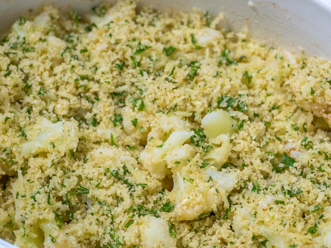 Pour cauliflower onto deep baking pan or casserole dish. Pour butter over top and then cover with buttered breadcrumbs. Bake for 10-15 minutes or until cauliflower begins to brown on top.