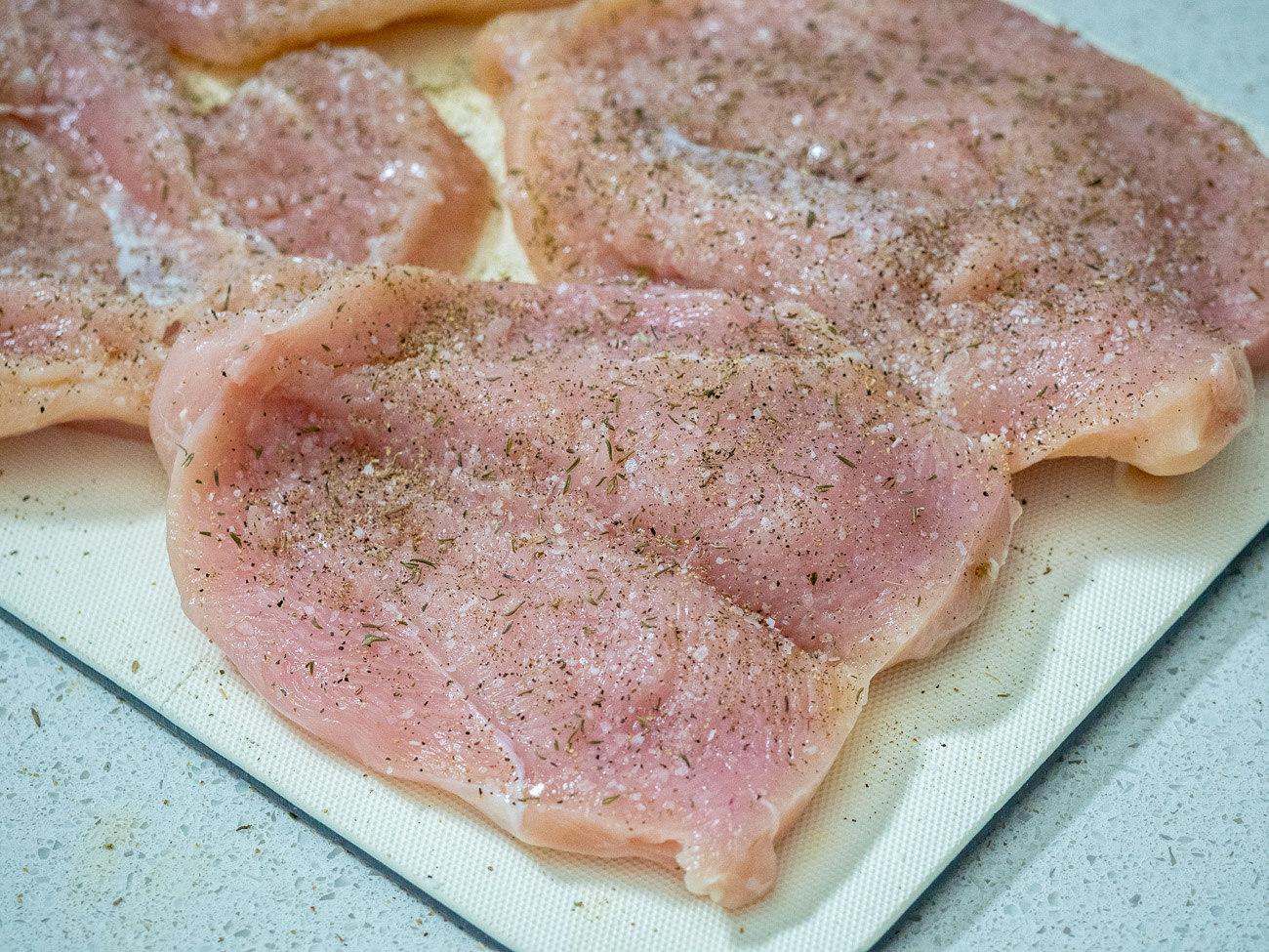 Butterfly the chicken breasts by cutting them horizontally so that they open up like a book and are attached on one side.