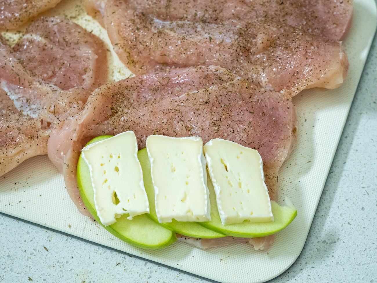 Sprinkle insides of chicken breasts with salt, black pepper, and thyme. Top with apple slices and brie cheese slices, using about 3 slices of each for each chicken breast. Fold each chicken breast over to close it up.