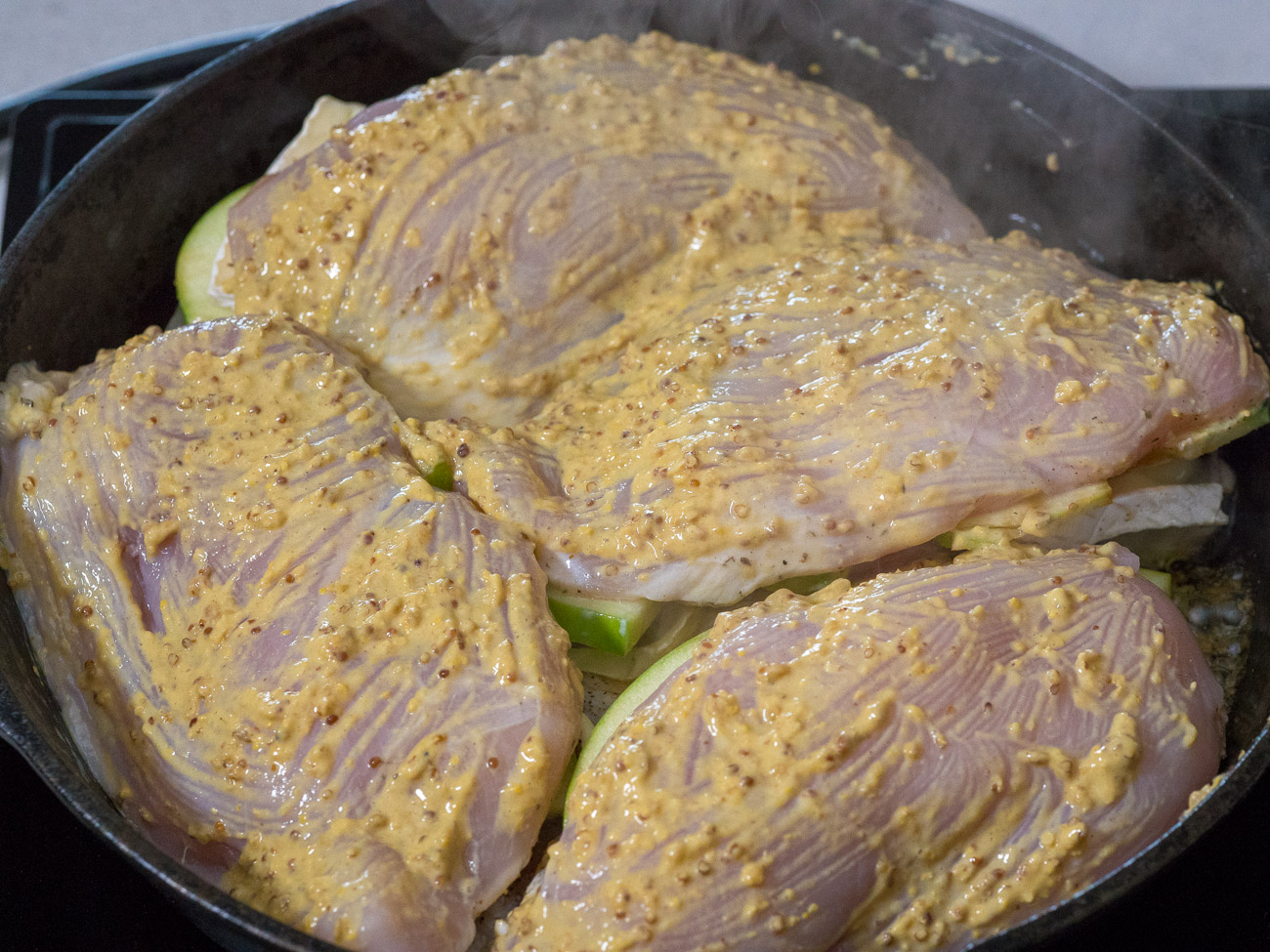 Mix together the mustards in a small bowl and brush half on the tops of the chicken breasts.