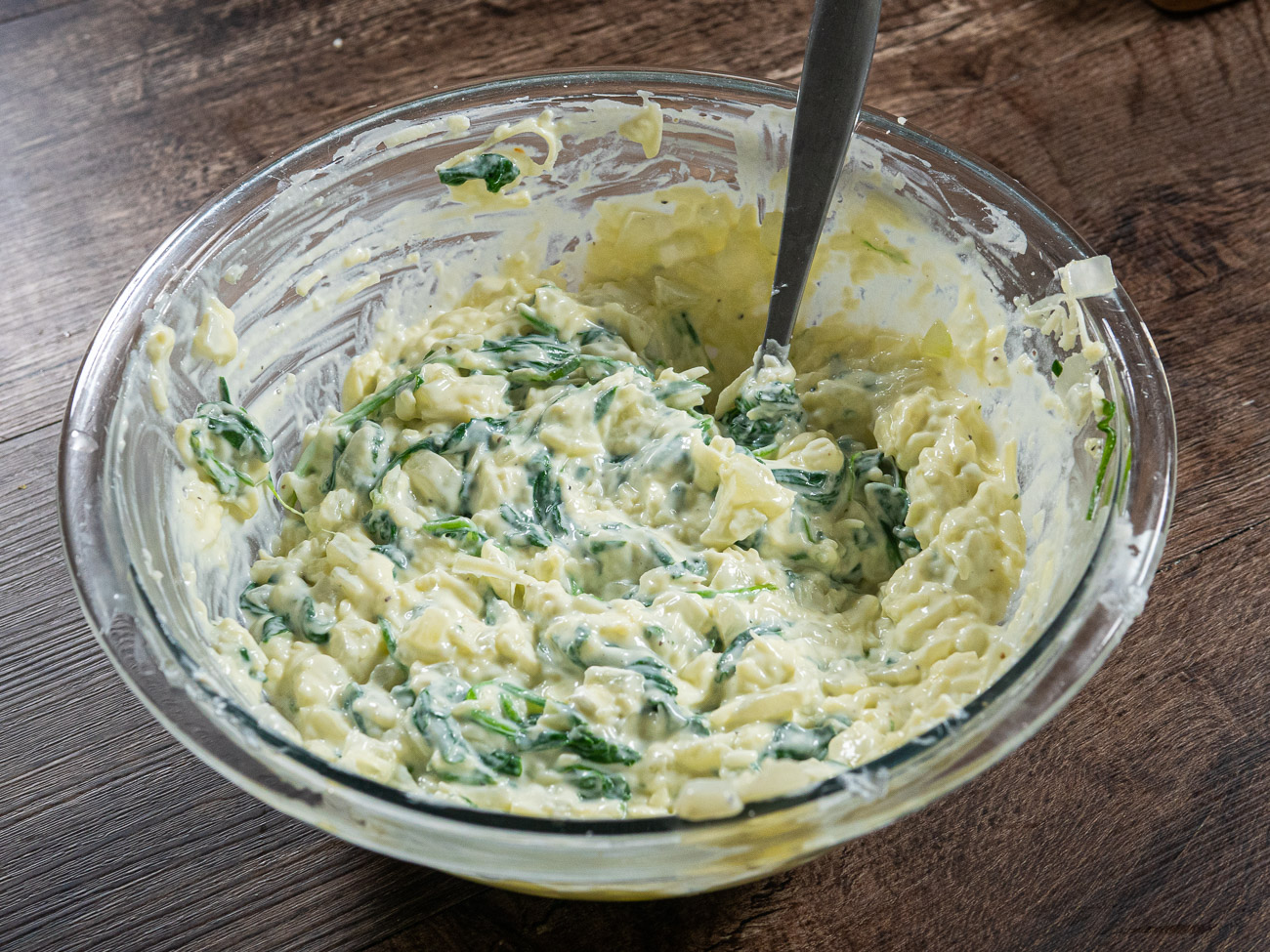 Remove spinach mixture to a bowl and mix with 1 cup ricotta, 1 1/2 cups mozzarella cheese, and egg. Set aside.