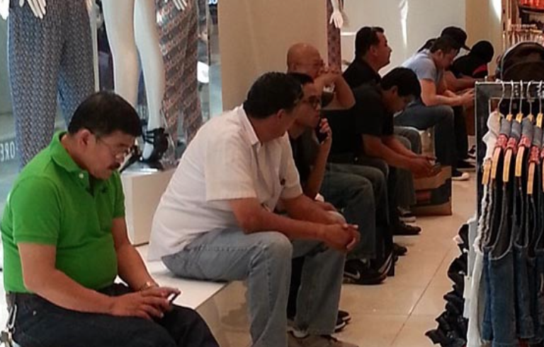 Photos Show “Miserable Men” Who’d Rather Be Anywhere But Shopping