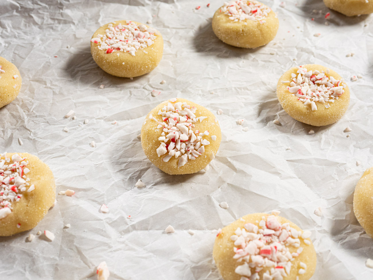 Spread cookies 2 inches apart on lined of greased baking sheets and slightly flatten each one. Top with crushed peppermint candy.