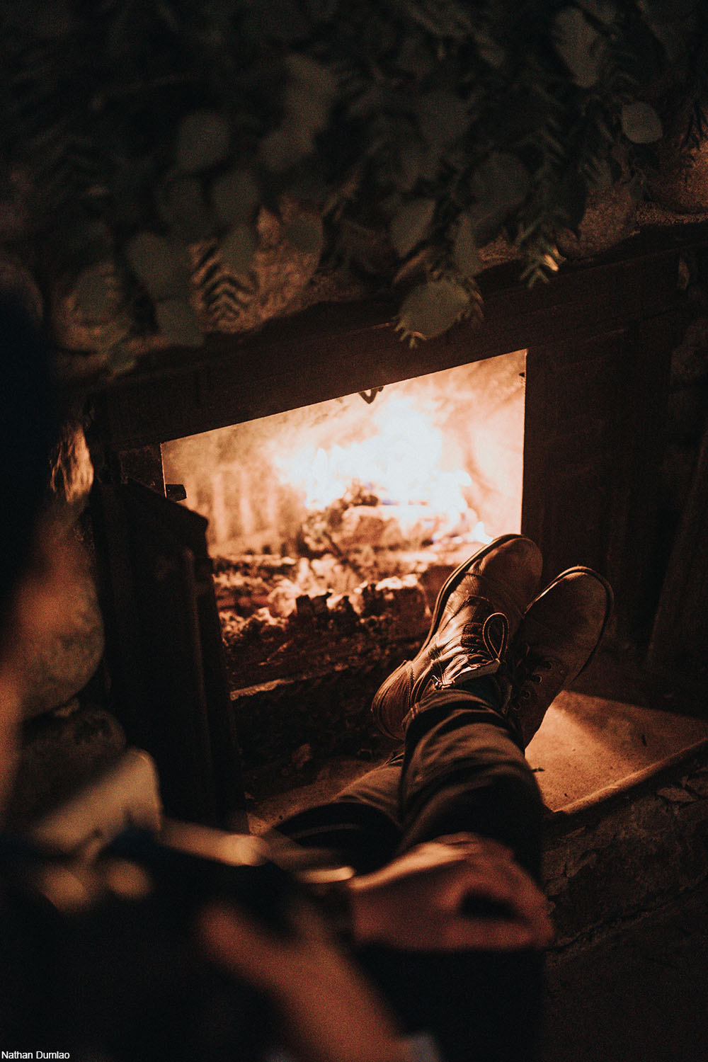 person relaxing in front of a fire