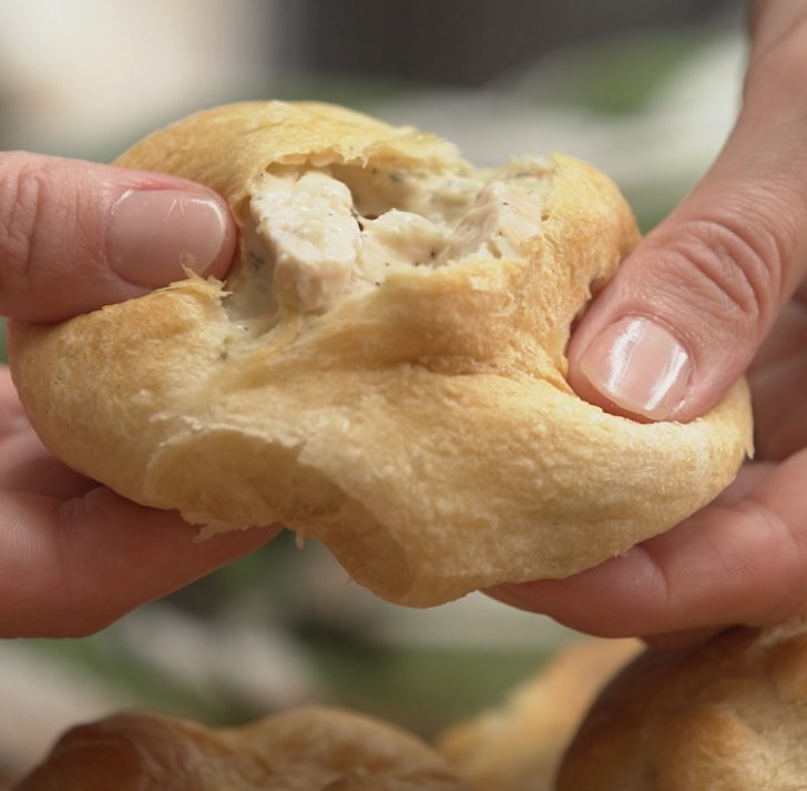 Pulling apart a ball of soft dough to reveal creamy chicken inside
