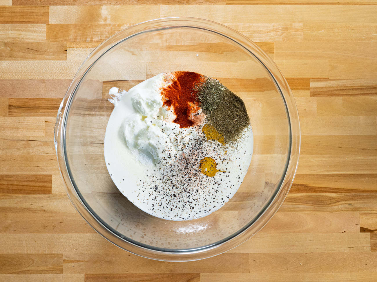 In a very large bowl whisk together cream, yogurt, eggs, melted butter, and spices.