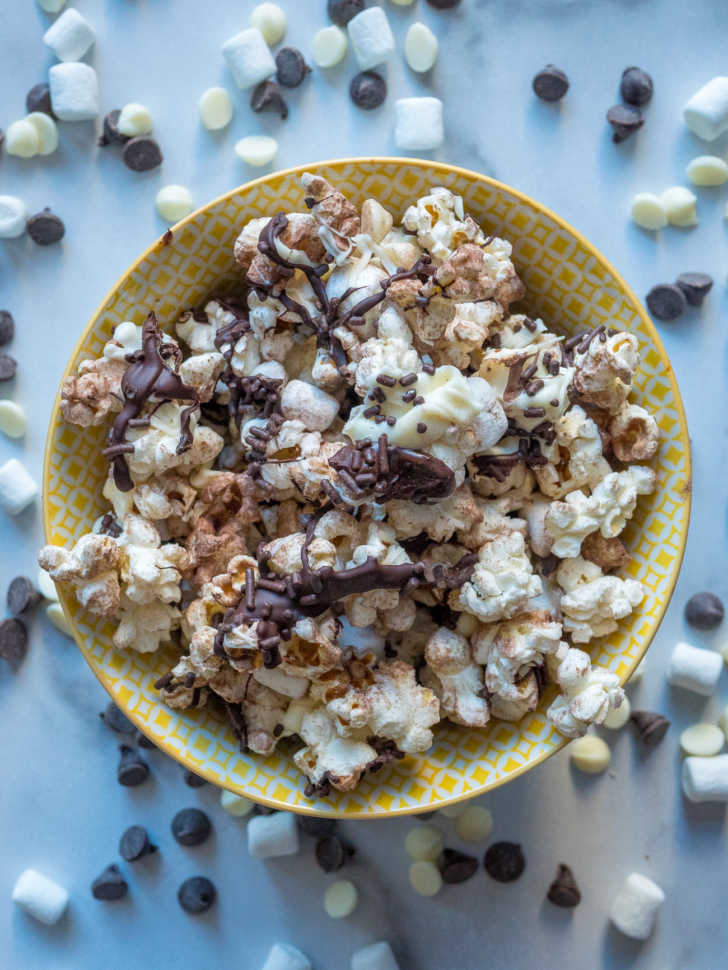 Bowl of popcorn with chocolate drizzled and cocoa powder sprinkled on top