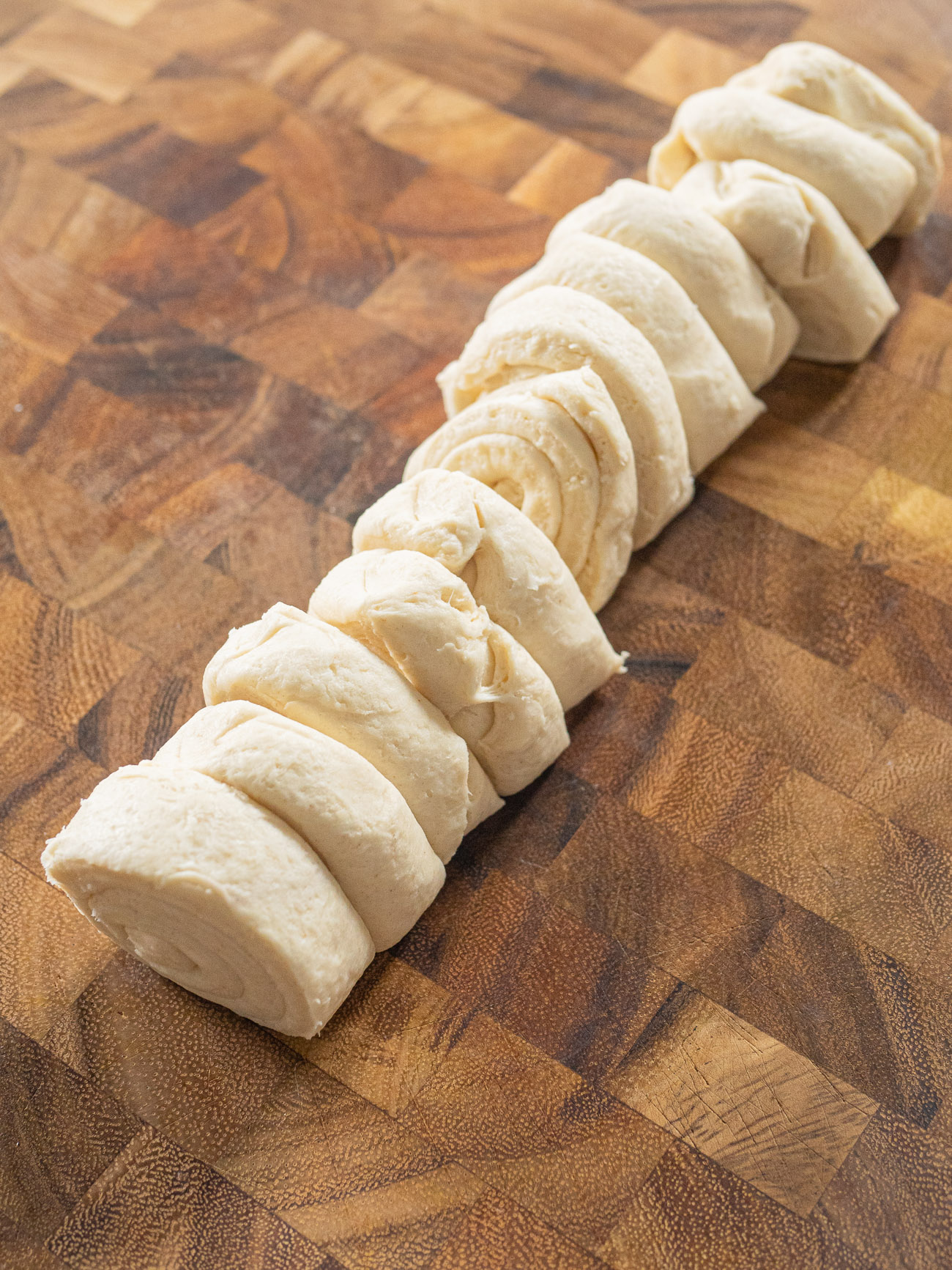 Remove crescent roll dough from package but do not unroll. Cut roll of dough into 12 equal slices.