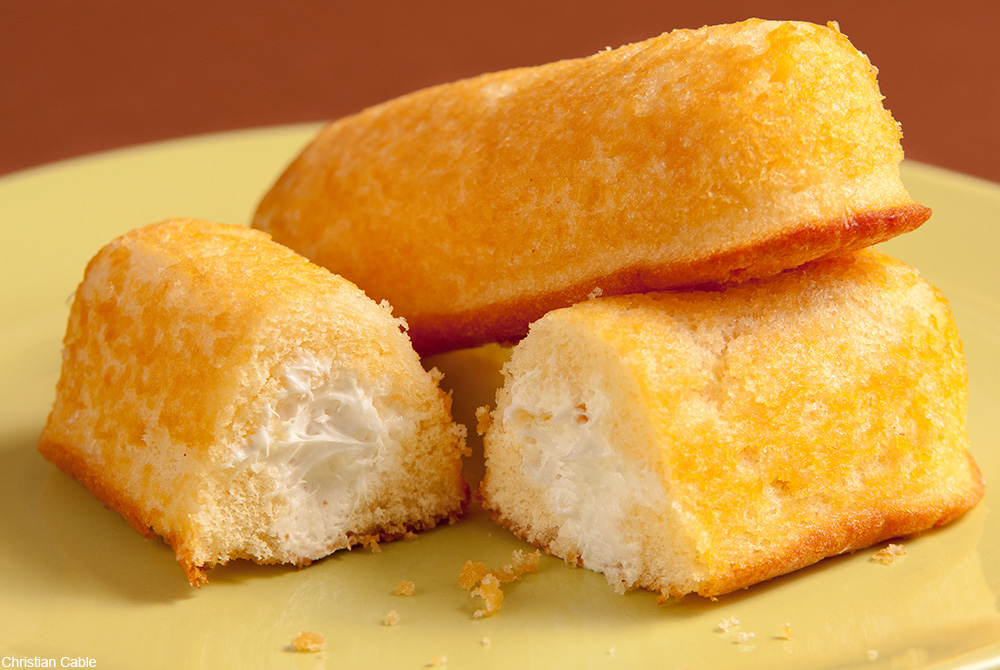 Twinkies stacked on a yellow plate