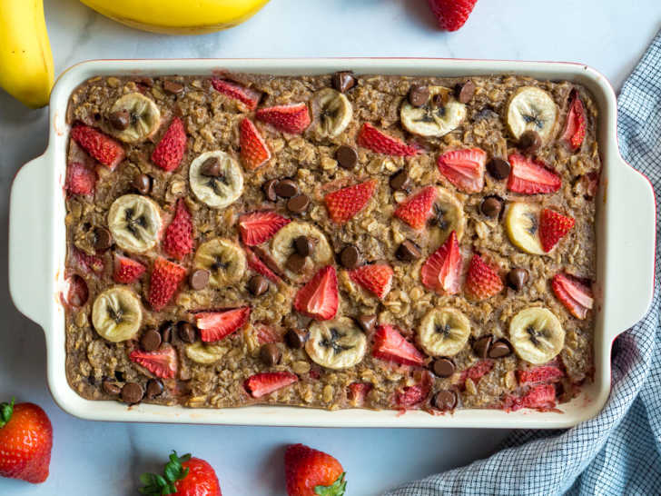 Top down photo of oatmeal bake with strawberries, bananas, and chocolate chips on top