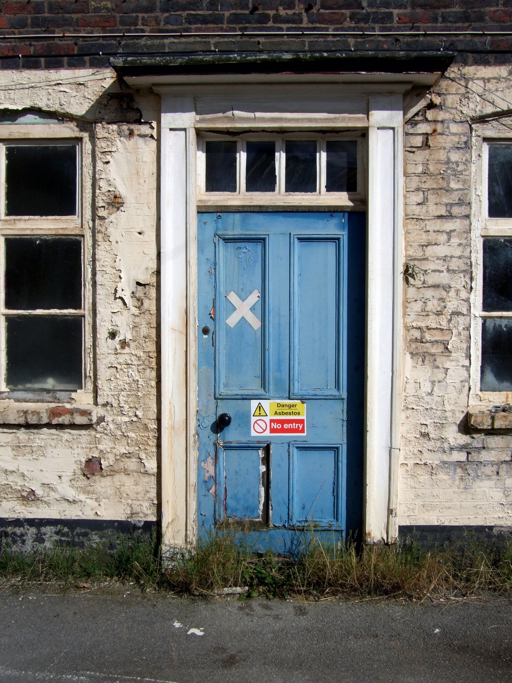 old house with asbestos warning on front door