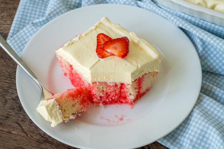 Top down view of strawberry cake on a plate with thick frosting