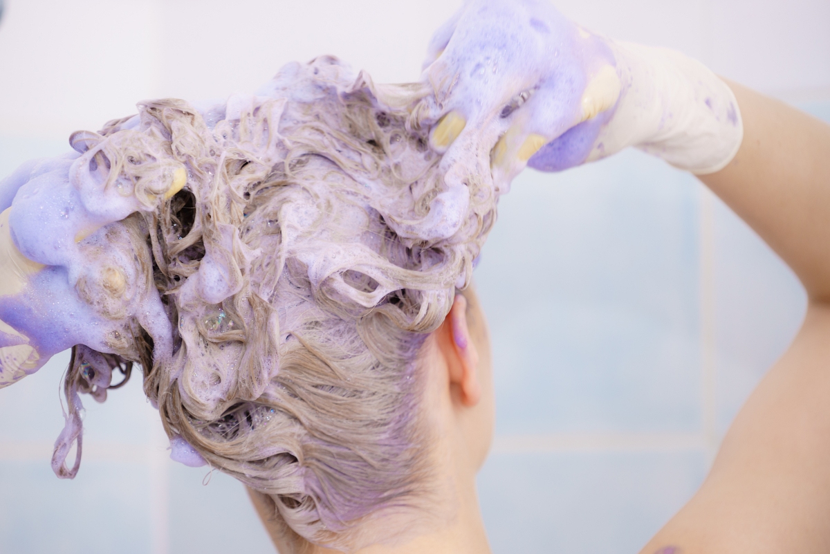 woman using purple shampoo in the shower