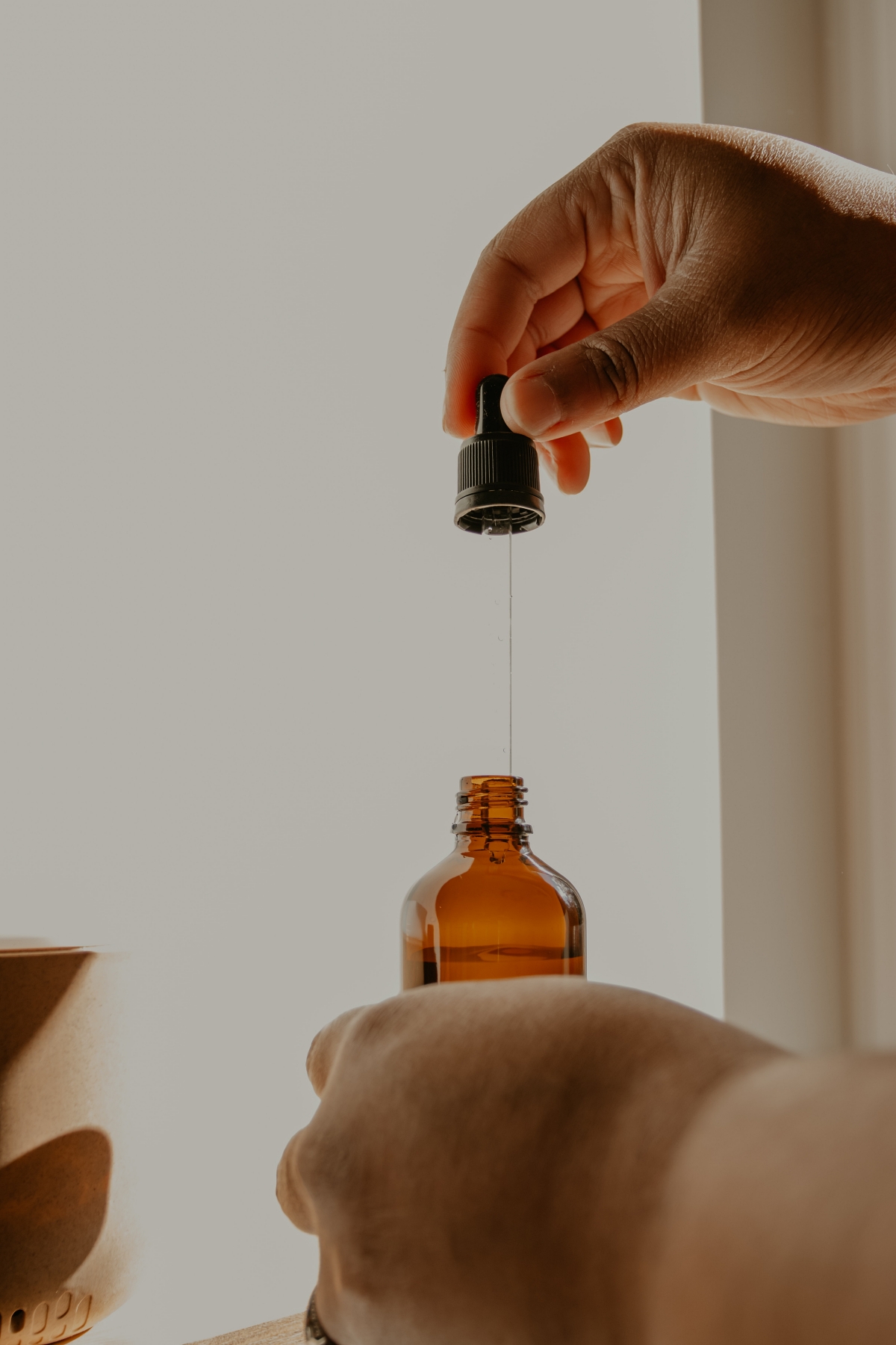 person using a dropper bottle full of liquid