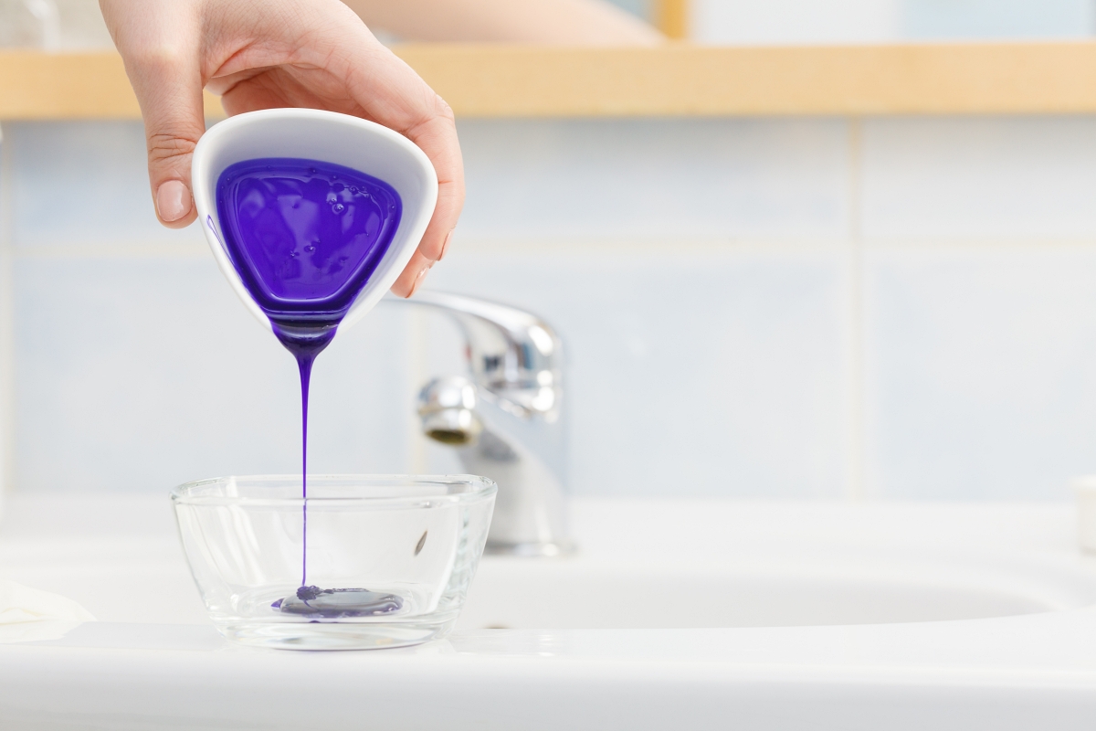 purple liquid being poured into a bow;