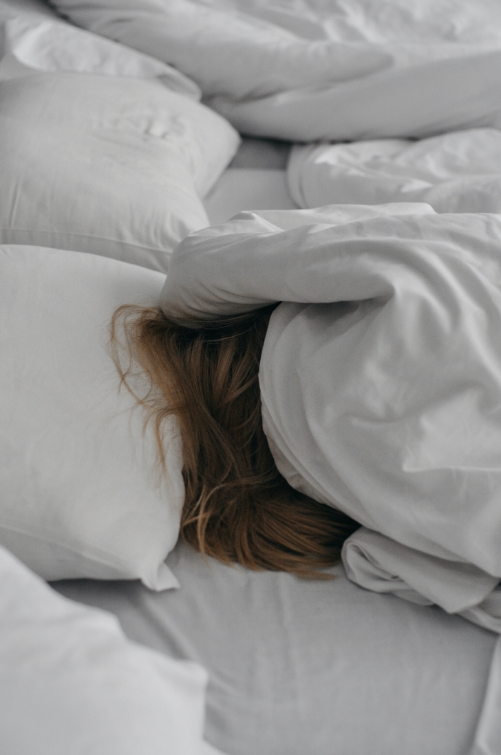 person sleeping in messy bed