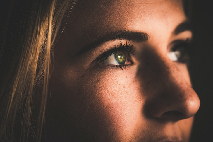 woman looking up in dark light