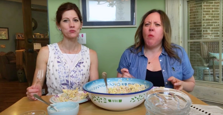 2 women tasting popcorn salad with bacon