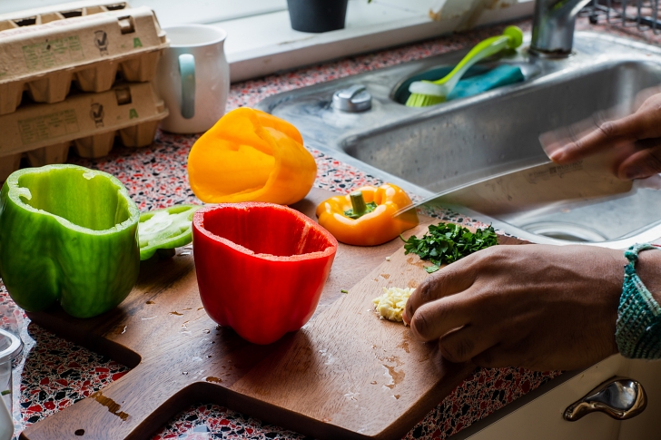 woman slicing bell peppers in a kitchen