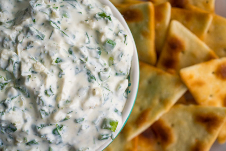 Close up of creamy dip with green onions in it