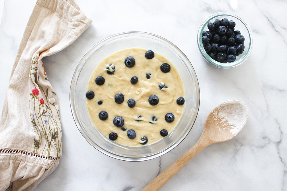 Bowl of creamy batter with blueberries sprinkled on top