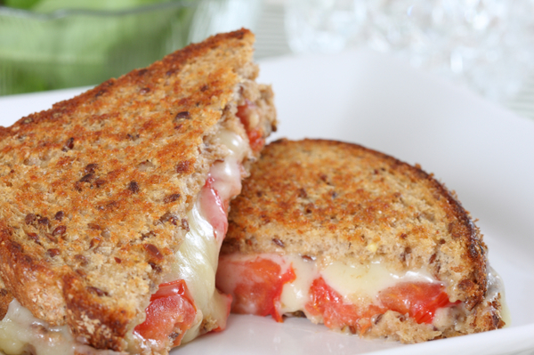 Grilled cheese with melting mozzarella and diced tomato.